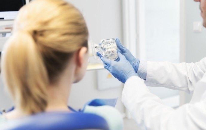 Dentist talking to patient during preventive dentistry checkup and teeth cleaning