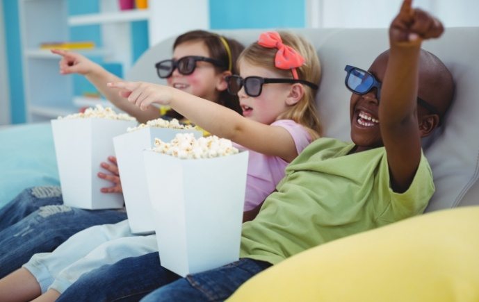 Kids smiling and eating popcorn after children's dentistry visit