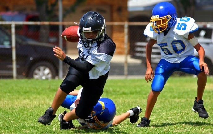 Children with athletic mouthguards playing football