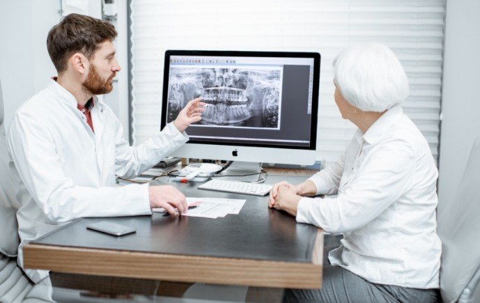 Dentist and dental patient discussing the cost of dental implants