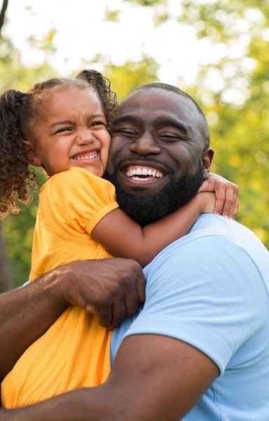 Father hugging daughter after children's dentistry visit