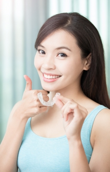 Woman holding Invisalign orthodontics tray