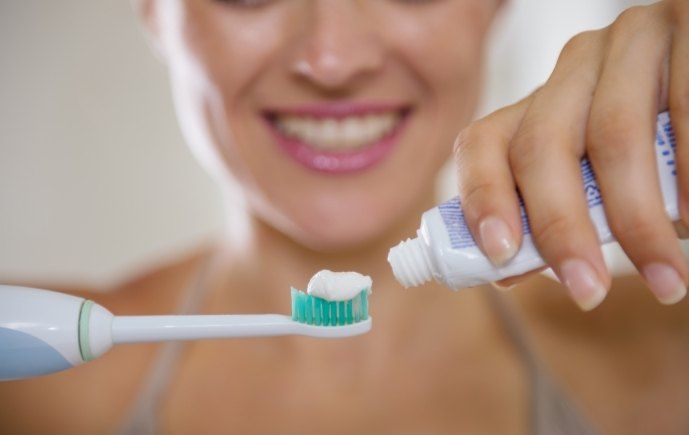 Person brushing teeth to prevent the need for root canal therapy